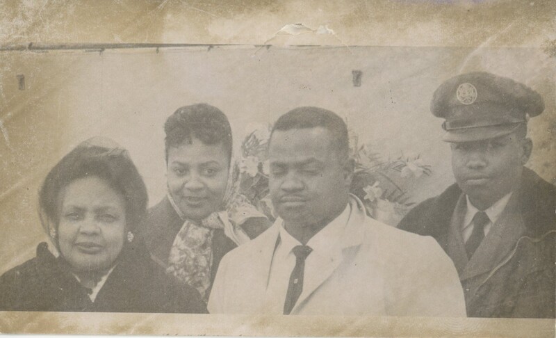 Four people standing together shoulder to shoulder.