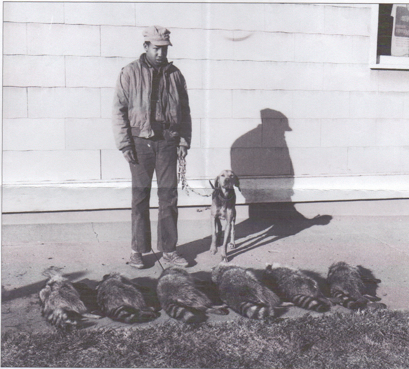A raccoon and it's handler standing in front og their catches.