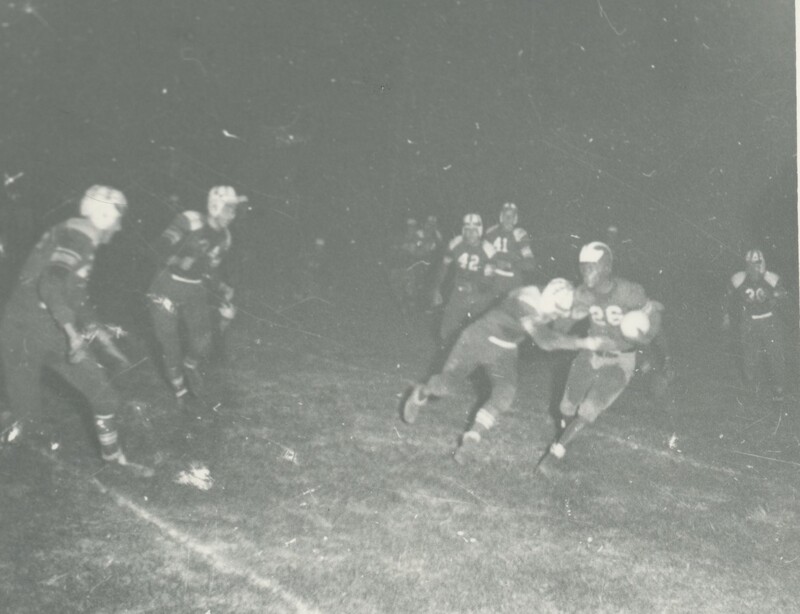 Multiple football players in the middle of a game.