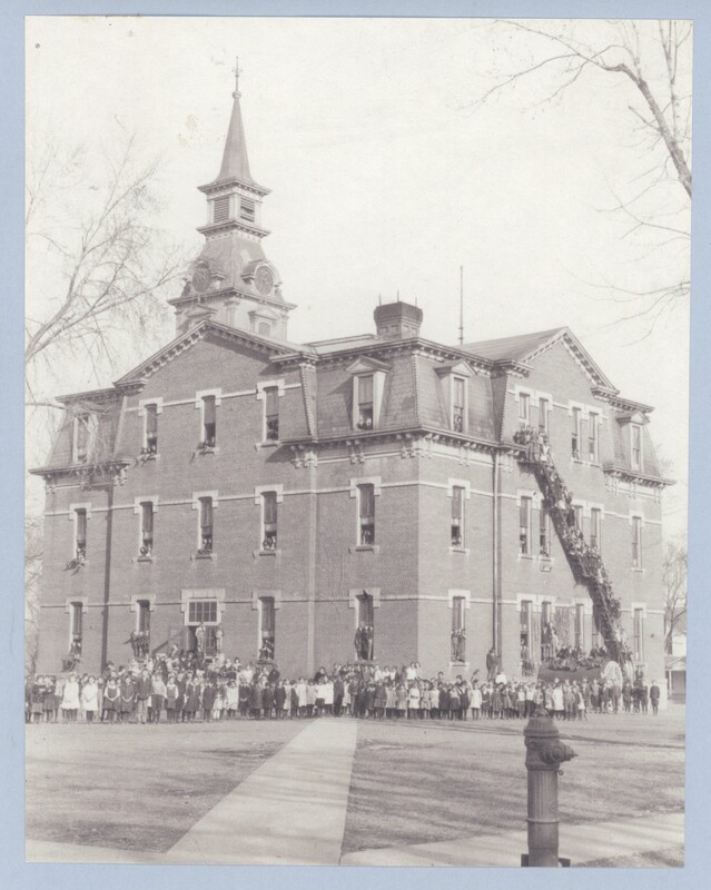 Clarinda Schools building with the students and staff at the time standing outside.