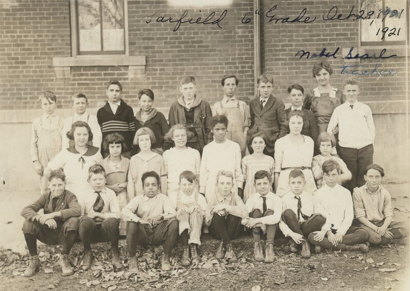 An integrated sixth grade class sitting, kneeling and standing next to eachother for a photo.
