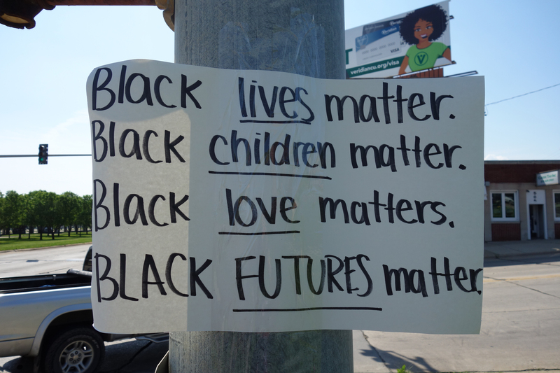 Digital image (5472 x 3648). Closeup of a white cardstock sign taped to a lightpost in Waterloo at the southwest corner of Washington and W 4th. "BLACK LIVES MATTER. BLACK CHILDREN MATTER. BLACK LOVE MATTERS. BLACK FUTURES MATTER." handwritten in black ink at anterior of sign.


Image taken on 6/4/2020 by Grout Museum District personnel. One of three such posters taped to lightposts at the intersections of Washington and W Park and Washington and W 4th in Waterloo, Iowa, before the George Floyd protest march of the night of 6/2-6/3/2020. The March began at the Black Hawk Co. Jail and was ultimately broken up by the Waterloo Police Department in Washington Park and on the 218 overpass. Grout Museum District staff collected the signs after they blew down in a storm on 6/5/2020.