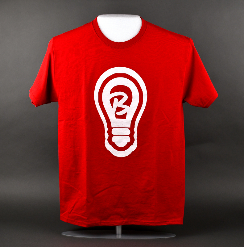Crew-necked short-sleeve t-shirt of red cotton/polyester blend. Machine-stitched.  Stylized letter “B” inside a lightbulb printed at center anterior.   

Graphic (Meant to be interpreted as the imperative: “Be light.”) is the personal brand of local businessowner Nia “ShinDigg” Wilder.  Pieces featuring the brand are commonly referred to as “Light Gear.” Wilder was a major organizer among Waterloo’s African-American community during the 2020 George Floyd Protests. Wilder sold/distributed “light gear” widely in 2020 and such pieces were commonly seen at local social justice events that year. Wilder was elected Ward 3 Waterloo City Councilperson in 2022.   

From donor Nia “ShinDigg” Wilder:

“Connecting to the Black Lives Matter Movement is more than just marching and protesting. To me, “Black Lives Matter” is ensuring that every Black Life understands how important they are and understands their role in making sure our community thrives. My mission with “Be Light” gear is to remind you WHO you are and WHY you are. Bringing Light into the community is my way of projecting something positive and owning that we all bare something in common, we all have a PURPOSE. BLACK LIVES MATTER!”