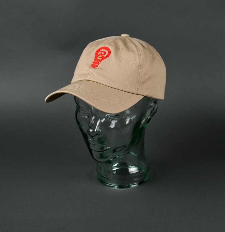 Ballcap of khaki cotton. Machine-stitched. Stylized letter “B” inside a lightbulb machine-embroidered in red thread at cap’s frontispiece.   

Graphic (Meant to be interpreted as the imperative: “Be light.”) is the personal brand of local businessowner Nia “ShinDigg” Wilder.  Pieces featuring the brand are commonly referred to as “Light Gear.” Wilder was a major organizer among Waterloo’s African-American community during the 2020 George Floyd Protests. Wilder sold/distributed “light gear” widely in 2020 and such pieces were commonly seen at local social justice events that year. Wilder was elected Ward 3 Waterloo City Councilperson in 2022.

From donor Nia “ShinDigg” Wilder:

“Connecting to the Black Lives Matter Movement is more than just marching and protesting. To me, “Black Lives Matter” is ensuring that every Black Life understands how important they are and understands their role in making sure our community thrives. My mission with “Be Light” gear is to remind you WHO you are and WHY you are. Bringing Light into the community is my way of projecting something positive and owning that we all bare something in common, we all have a PURPOSE. BLACK LIVES MATTER!”