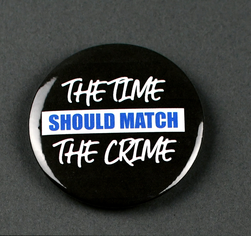 Button with safety pin clasp at posterior. Graphic at anterior printed on paper and crimped under transparent plastic covering. "THE TIME SHOULD MATCH THE CRIME" in white and blue on black background.

Button made and sold/distributed by Amani Community Services during the 2020 George Floyd Protests in Waterloo. Amani community services is a domestic violence and sexual assault prevention agency serving African Americans in Black Hawk and Linn Counties with offices in Waterloo and Cedar Rapids. 