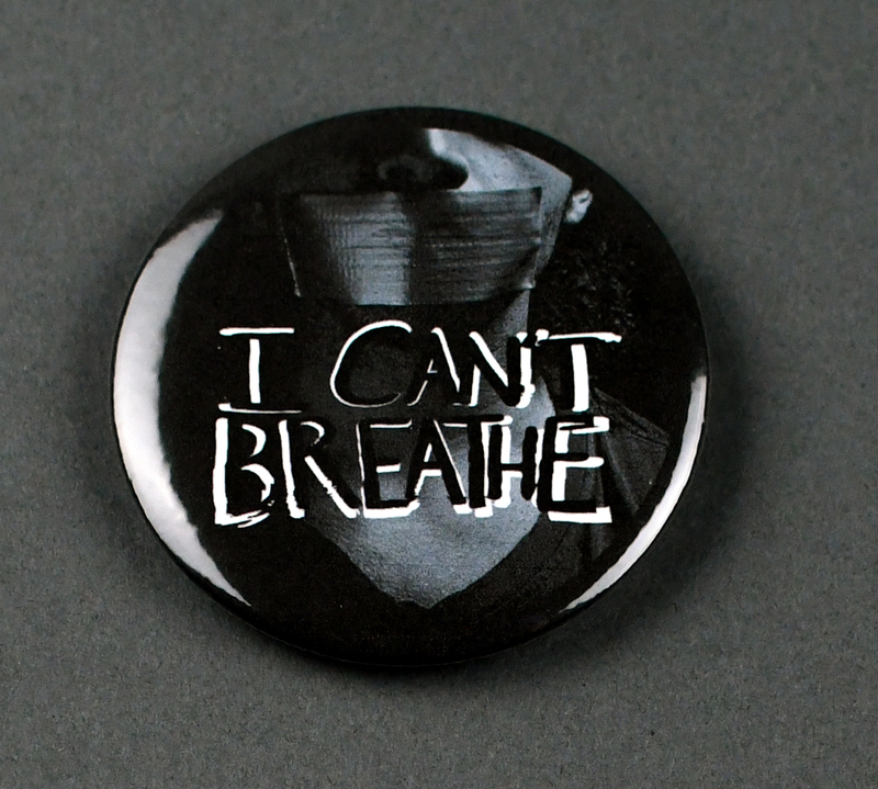 Button with safety pin clasp at posterior. Graphic at anterior printed on paper and crimped under transparent plastic covering. "I CAN'T BREATHE" in black with white over darkened black and white image of person with duct tape gag.

Button made and sold/distributed by Amani Community Services during the 2020 George Floyd Protests in Waterloo. Amani community services is a domestic violence and sexual assault prevention agency serving African Americans in Black Hawk and Linn Counties with offices in Waterloo and Cedar Rapids. 
