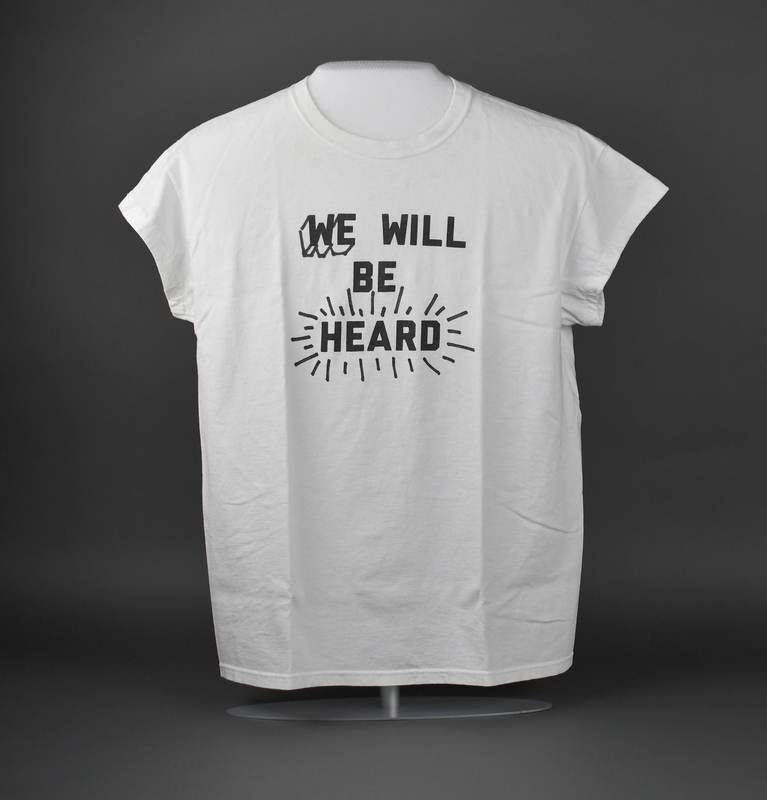 Crew-necked short-sleeve t-shirt of white cotton. Machine-stitched. “WE WILL BE HEARD” printed in black at upper center anterior.   

Worn by Black Hawk County Democrats Chairwoman Vikki Brown during the May 29, 2020 George Floyd Protest in Waterloo. The May 29 protest began with a march from Veterans Memorial Hall to Lincoln Park and concluded with speeches made in the park. 
Brown grew up in Birmingham, Alabama and participated in the "Children's Crusade" (May 2-3, 1963) when she was 11 years old.  She was personally acquainted with one of the victims of the 16th Street Baptist Church Bombing (September 15, 1963).

From donor Vikki Brown:

“The civil rights movement in the south was very unstable during the Jim Crow era of the 1950s and 1960s; and at times it was also violent. Growing up in Birmingham, Alabama during that era as a little girl, I felt compelled to participate on the right side of history as a Child Crusader. Fearing for our safety, my mother wouldn’t allow me nor my sisters to go near the chaos, but in 1963 at the age of 11 I sneaked down with classmates and marched against injustice. The ugliness hit close to home when a neighborhood acquaintance, also 11 years old, lost her life in the 16th Street Baptist Church bombing in September of that same year. Today, 57 years later I still continue with a vision on the right side of history. I have always, and I will continue to have a personal commitment to making a positive difference and impact in my community far and wide.”