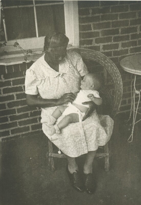 A person holdng a baby laying in her lap.