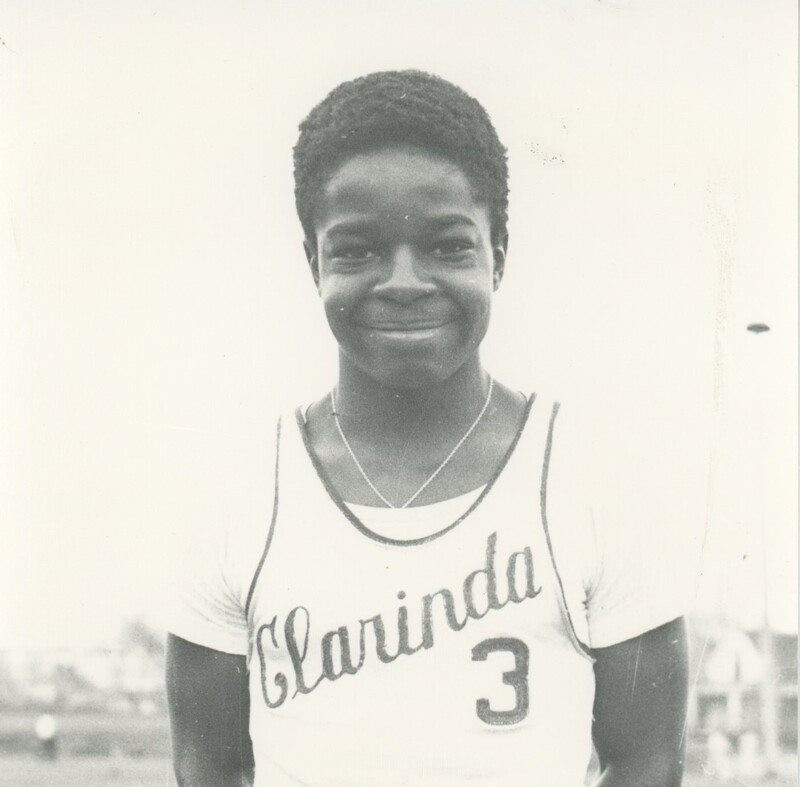A young child smiling for a photo and wearing a sports jersey.