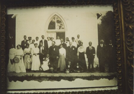 The members of the church stand outside the front doors of the St. Jacobs AME Church.