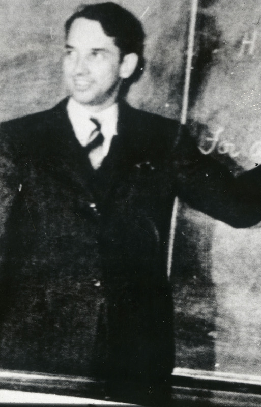 The young John Vincent Atanasoff standing in front of the blackboard.