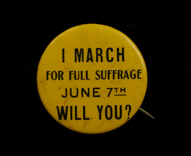 Round yellow button with "I MARCH; FOR FULL SUFFRAGE; JUNE 7TH; WILL YOU?" in black lettering on the front. The march took place in Chicago, Illinois during the 1916 Republican National Convention.