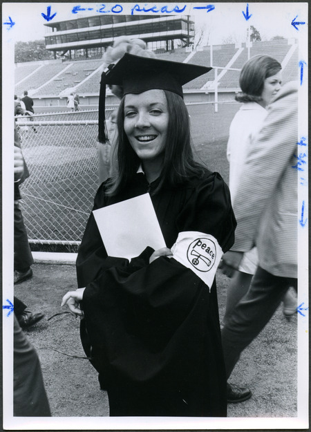 An Iowa State graduate proudly displays an armband with the word peace following Commencement in 1970.