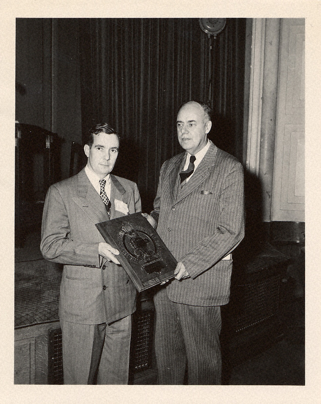 Photograph of a corn trophy being given to Iowa's top corn producer.