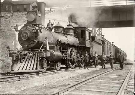 Photograph of a corn train's exterior, with five of the crew standing beside it. Taken in 1910.