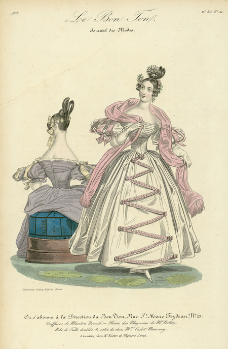 Woman's Dress, made out of tulle and trimmed in satin, including a shirred overlay trimmed in lace (both front and back) over a fitted bodice, short puffed sleeves with contrasting fabric cutouts and ribbon, a full skirt decorated with a zigzag decoration beginning at the waist. The coiffures are elaborately braided and rolled, and decorated with flowers and ribbon. There is also a matching wrap. No jewelry is included (published for Le Bon Ton, Journal des Modes by M. Foster, 16 Wigmore Street, London).