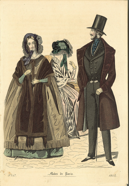 Walking dress shown under a loose cape with a shawl over the cape and a bonnet. The cape has a bow and a lace collar, the shawl is trimmed with tassels, and the bonnet has ribbons and feathers. The man is wearing a topcoat with a roll collar over a double breasted tail coat, fitted trousers with an in-step strap, a cravat, a top hat, a cane and he has a very narrow waist. (Published for Modes de Paris).