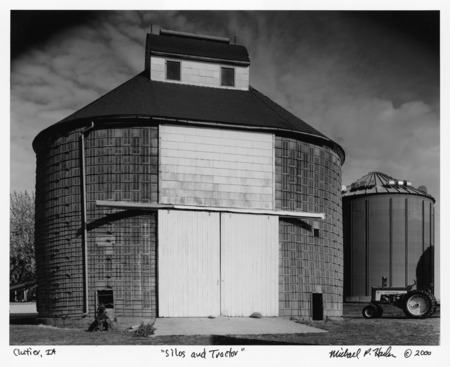 Photograph of a barn taken in Clutier, Iowa, entitled "Silos and Tractor."