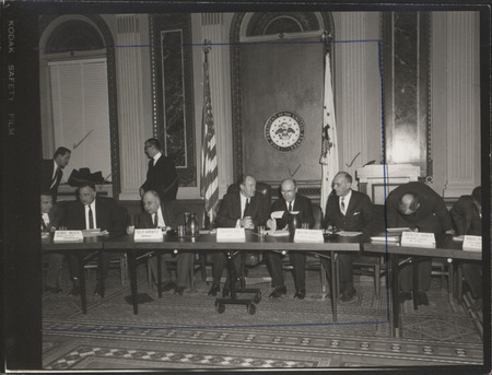 Photograph of Dwight Ink with others sitting around tables at the Indian Treaty Room