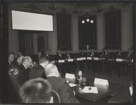 Photograph of Dwight Ink with others sitting around tables at the Indian Treaty Room