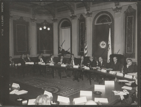 Photograph of Dwight Ink with others sitting around tables at the Indian Treaty Room