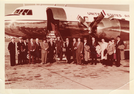 Photograph of Dwight Ink with a group of people standing in the runway near a United States aircraft
