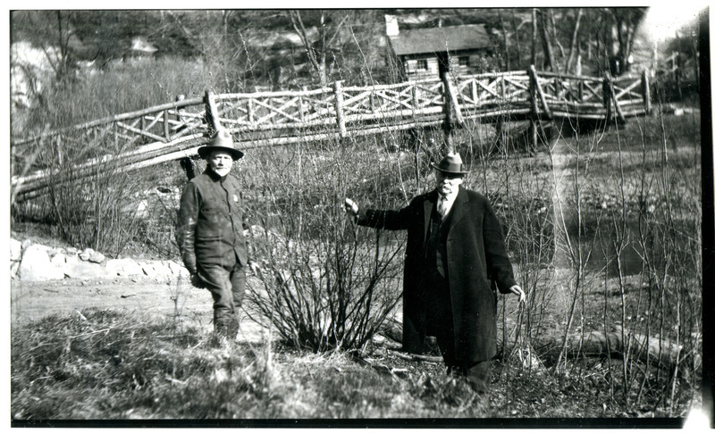 A black and white photograph showing Professor Pammel standing in front of a bridge with Carl Fritz Hemming at Ledges State Park.