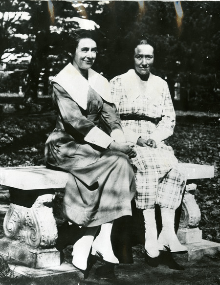 A black and white photograph showing Ada Hayden and Charlotte King seated on a bench on Iowa State University campus.