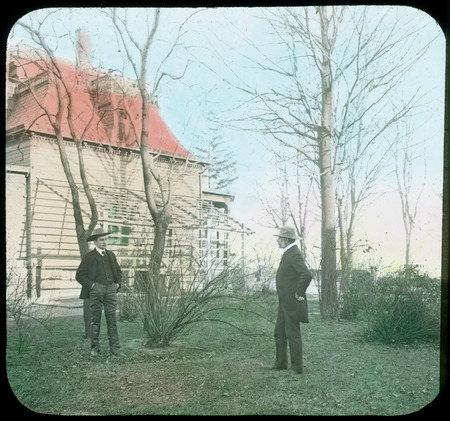 Colored slide showing house and yard, towmen in foreground.