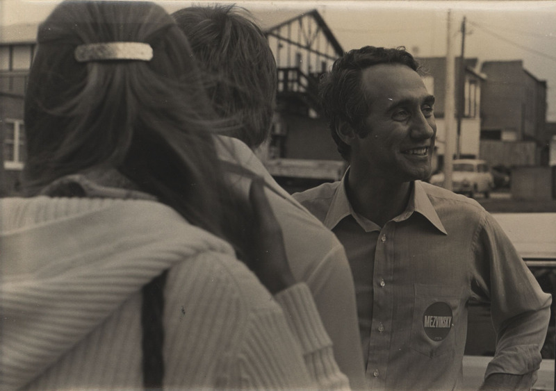 A photograph of Edward Mezvinsky speaking to two constituents.