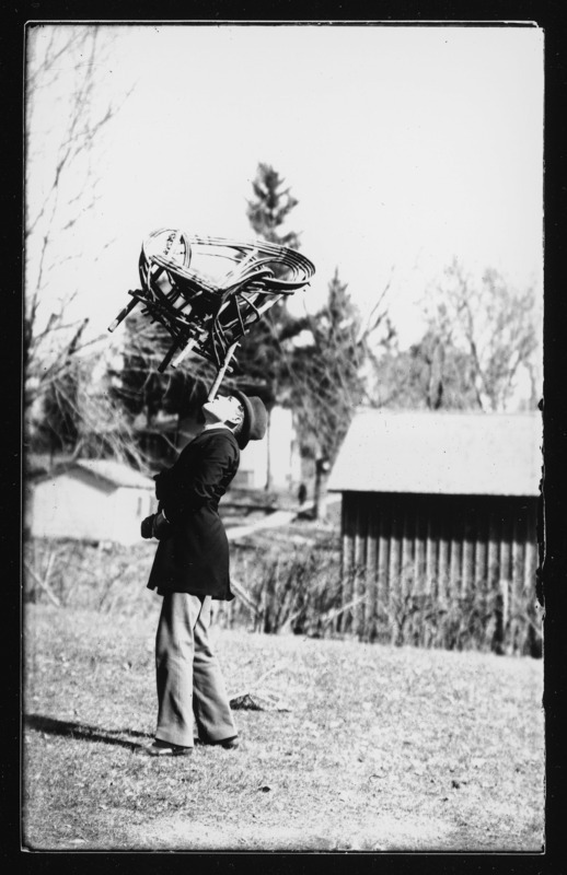 Professor Carter was a traveling entertainer. In this photograph he is balancing a wooden chair on his chin.
