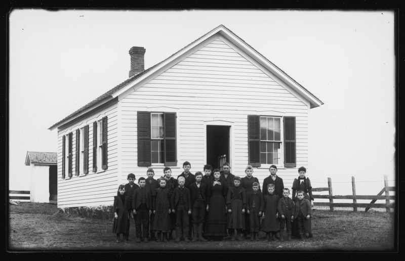 Unity School, west of DeWitt, Iowa. Teacher and students posed outside the one-room schoolhouse.