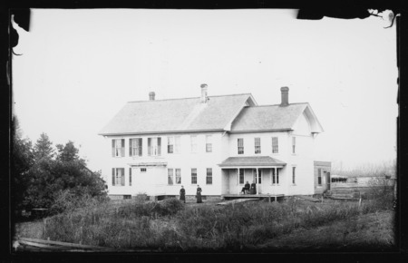 Pascal house, east of Grand Mound, Iowa. George W. Pascal and Talitha Cumi Pascal are on the front porch. Daughters Laura and Arcana (Lettie) are in the front yard.
