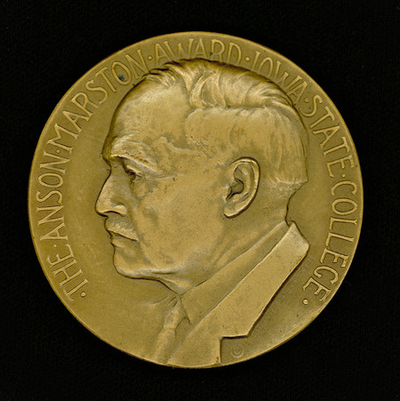 Medal awarded for achievement in engineering by an ISU alumnus, in the fields of technical construction, design, planning, development, and management, as well as teaching and research. The award was established by Iowa State College through the generosity of Anson Marston, Professor of Civil Engineering (1892-1920) and Dean of Engineering (1904-1932). He was named Dean Emeritus in 1938. The medal was originally to be made of gold, and awarded no more than once a year. This medal is one of two, which was sent to Christian Petersen by the Medallic Art Company (New York, New York) for him to use in exhibits as needed. Recto: depicts Iowa State University College of Engineering Dean Anson Marston in profile, wearing a suit and tie. Verso: depicts a scene with bridges, a river, a dam, a tower, and buildings. Recto inscription: THE ANSON MARSTON AWARD-IOWA STATE COLLEGE. Verso inscription: AWARDED FOR ACHIEVEMENT IN ENGINEERING. Cco: Medal cast in bronze