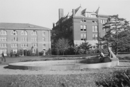 View of Marriage Ring fountain basin (terra-cotta 1942) with Catt Hall behind it. Located near MacKay Hall. Cco: Silver gelatin photograph on board