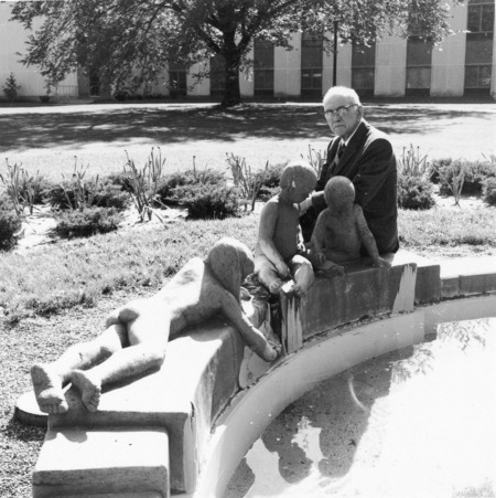 Christian Petersen sitting on the Marriage Ring fountain basin (terra-cotta, 1942) located near MacKay Hall. Cco: Silver gelatin photograph on board