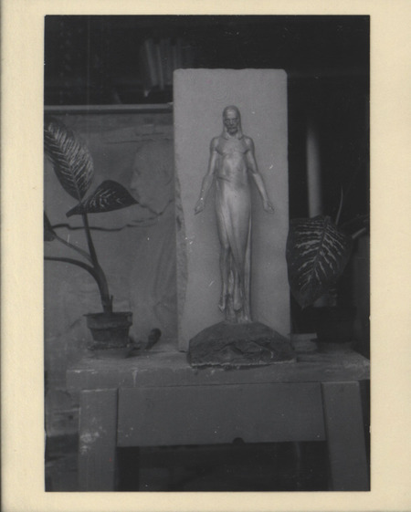 Black-and-white photograph of "Cemetery Christ: Model for Campus Cemetery" model made of painted plaster, a clay base and limestone plinth behind the figure.