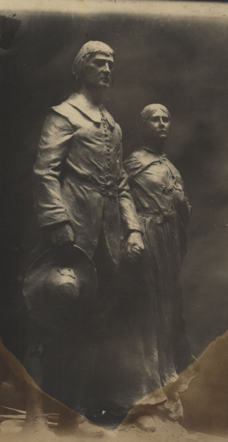 A painted plaster sculpture of a male and female free-standing figures.
