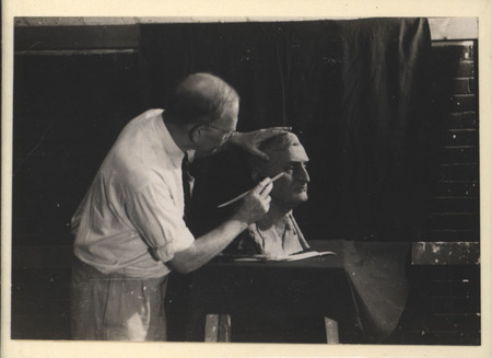 Photograph showing Christian Petersen sculpting a portrait bust of Kirk Fox, who was editor of the Des Moines Publishing House.