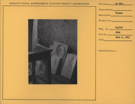 Photograph of the interior of Christian Petersen's artist studio with several bas-reliefs and molds leaning against a wall.