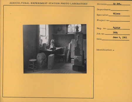 Photograph of the interior of Christian Petersen's artist studio with a desk, with bas-reliefs and in progress sculptures visible.