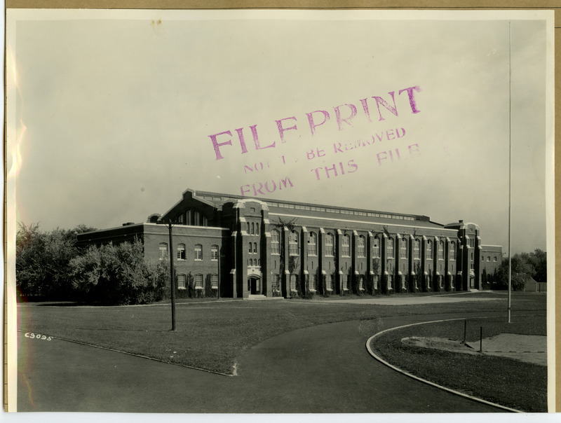 The State Gymnasium is viewed from the southwest side, looking across the track around Clyde Williams Field.