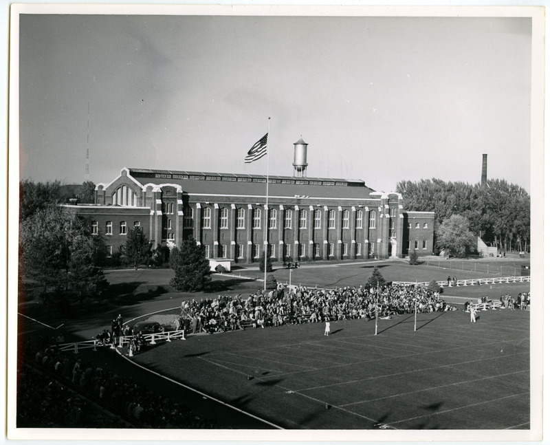 Spectators fill bleachers in the end zone of Clyde Williams Field in back (south) of the State Gymnasium, viewed from the southwest bleachers.