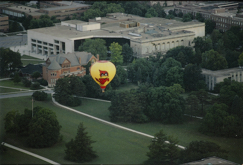 Aerial view of Iowa State University Library (now Parks Library), probably in the 1980's. A hot-air balloon with a Cy decal can be seen in the foreground.