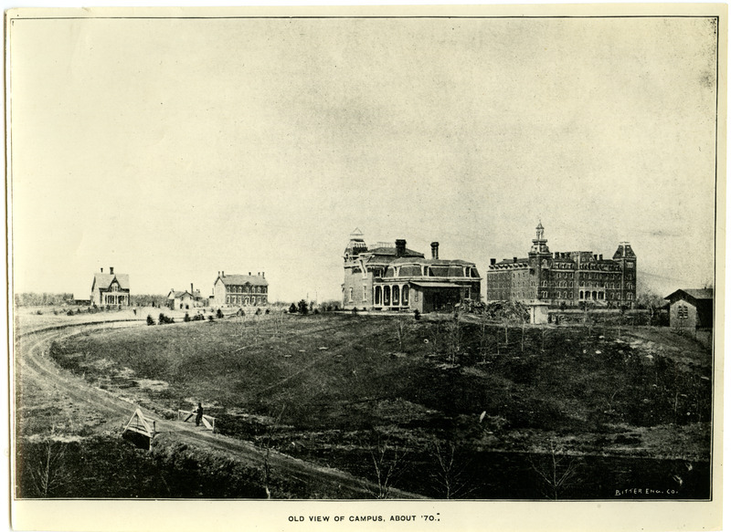 This picture "taken about '70" probably was taken in 1876. Large building at right rear is the Main Building, built in 1868, with an additional wing built in 1871. It burned about the turn of the century, and was replaced by a new limestone building which was first known as Central and now is known as Beardshear Hall (after an early president). Beardshear is near center of present campus and is headquarters for the administration of the college as well as classroom building. Building in foreground is president's residence, built in 1869. At far left (rear) is the Maples, built in 1869, and now known as Music Hall, the headquarters of the music department. (It is only building visible in picture still standing.) In left center toward rear is Chemistry Building, built in 1870 with an addition in 1875. Smaller building behind Chemistry is not completely identified.