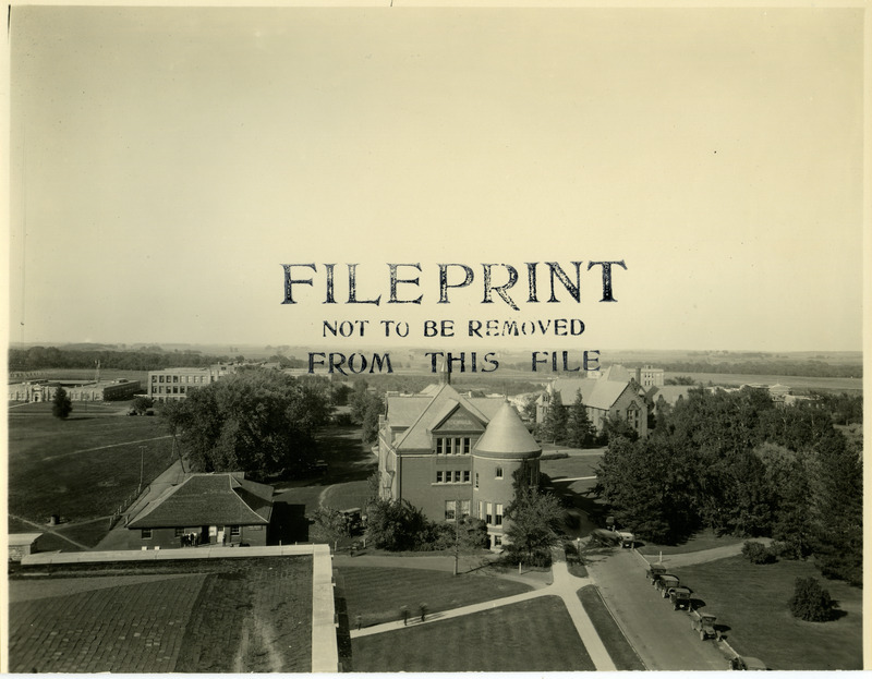 In this view from above, the campus buildings from left to right are the Hub, Morrill Hall, and Ladies Hall (later known as Margaret Hall). Cars of this era are moving past Morrill Hall and people are standing outside the Hub, October, 1922.