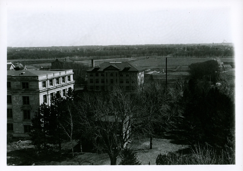 Iowa State University. Picture was probably taken in 1908 just before Curtiss Hall was completed in 1909. Sloss House visible in trees (lower center of the photograph, just a little to the left). Agricultural Annex can be seen in the background.