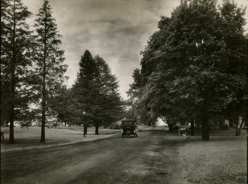 Car driving down dirt road in 1918. Picture may have been taken near the campus of Iowa State University.