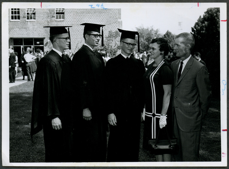 The three Benge brothers, left to right Phillip and twins Ronald and Roger, are standing in their cap and gowns next to their parents Mr. and Mrs. Loran Benge, 1967.