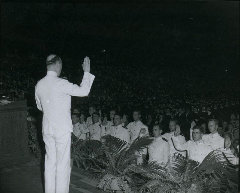 Naval officers are taking an oath at the commissioning of naval officers during commencement ceremonies, 1952.